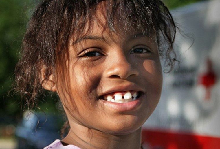 A little girl smiling.